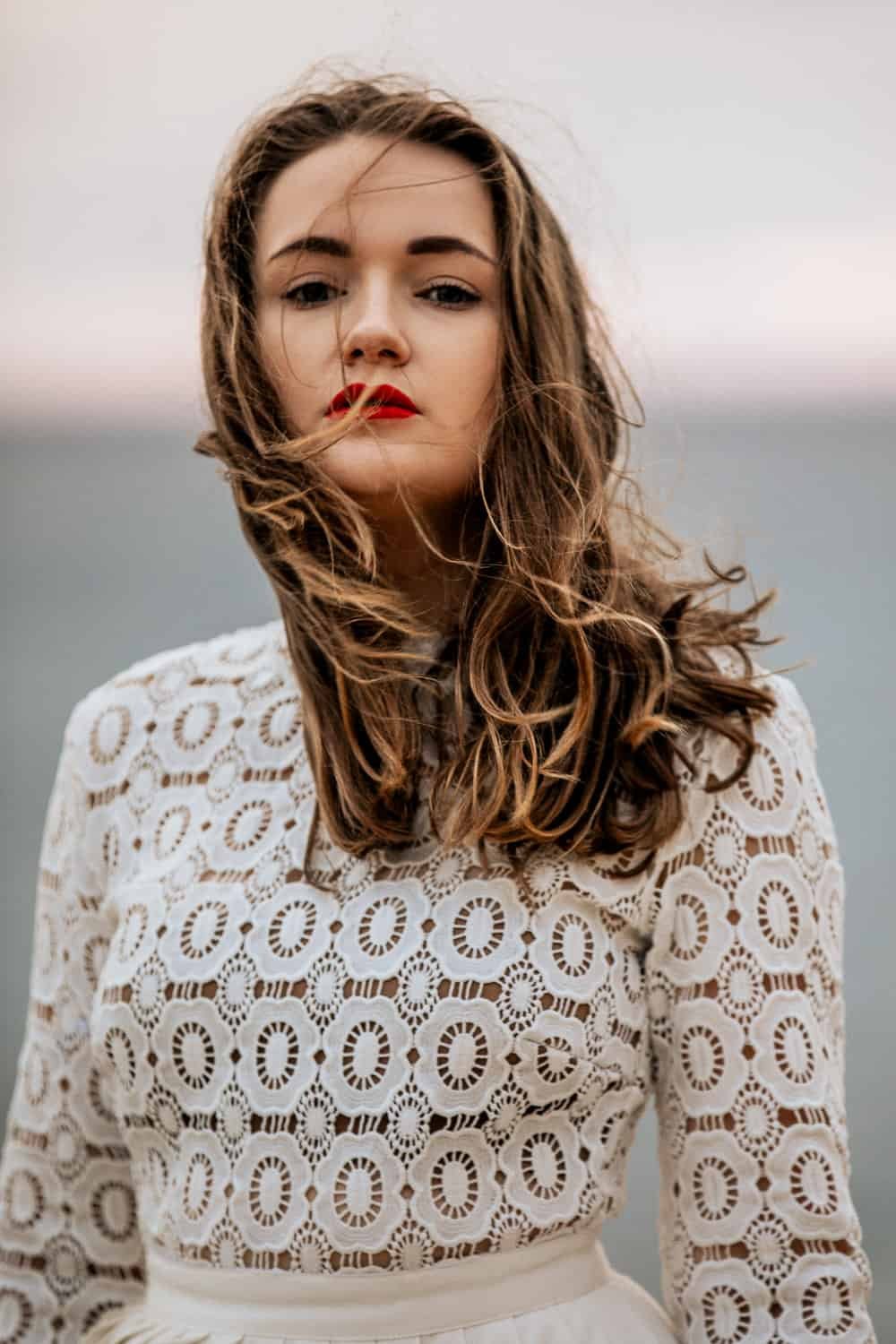 Portrait of a woman in a white lace dress by the sea in Cyprus