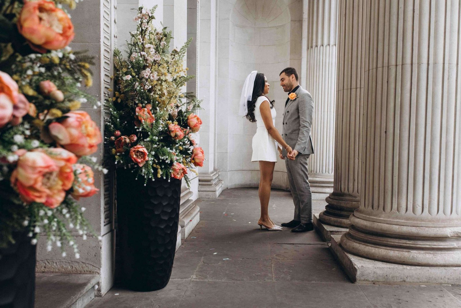 Couple beside flowers and architectural columns — Adrian Mazur wedding portfolio