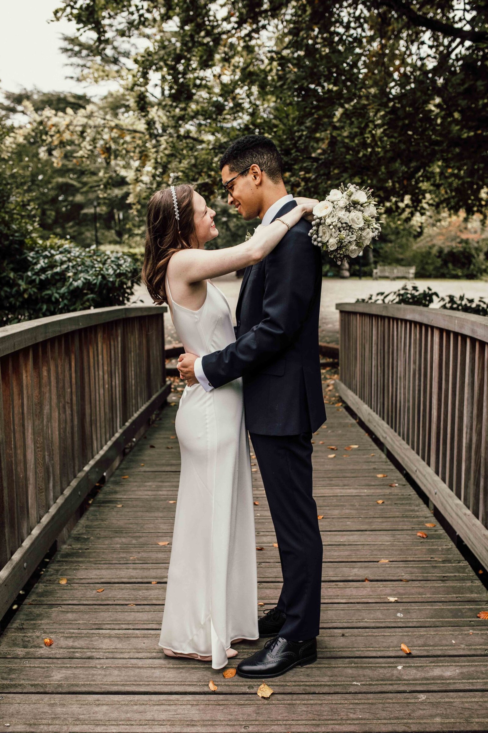 Katherine and Nathanaël sharing a kiss on a garden bridge
