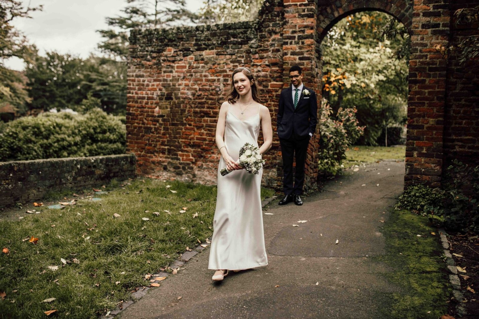 Katherine and Nathanaël beside a brick garden arch at Tudor Barn