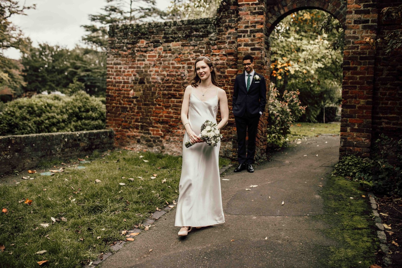 Katherine and Nathanaël beside a brick garden arch at Tudor Barn