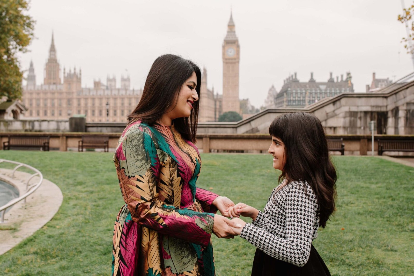 Mother and daughter together beside the Thames with Westminster in the background