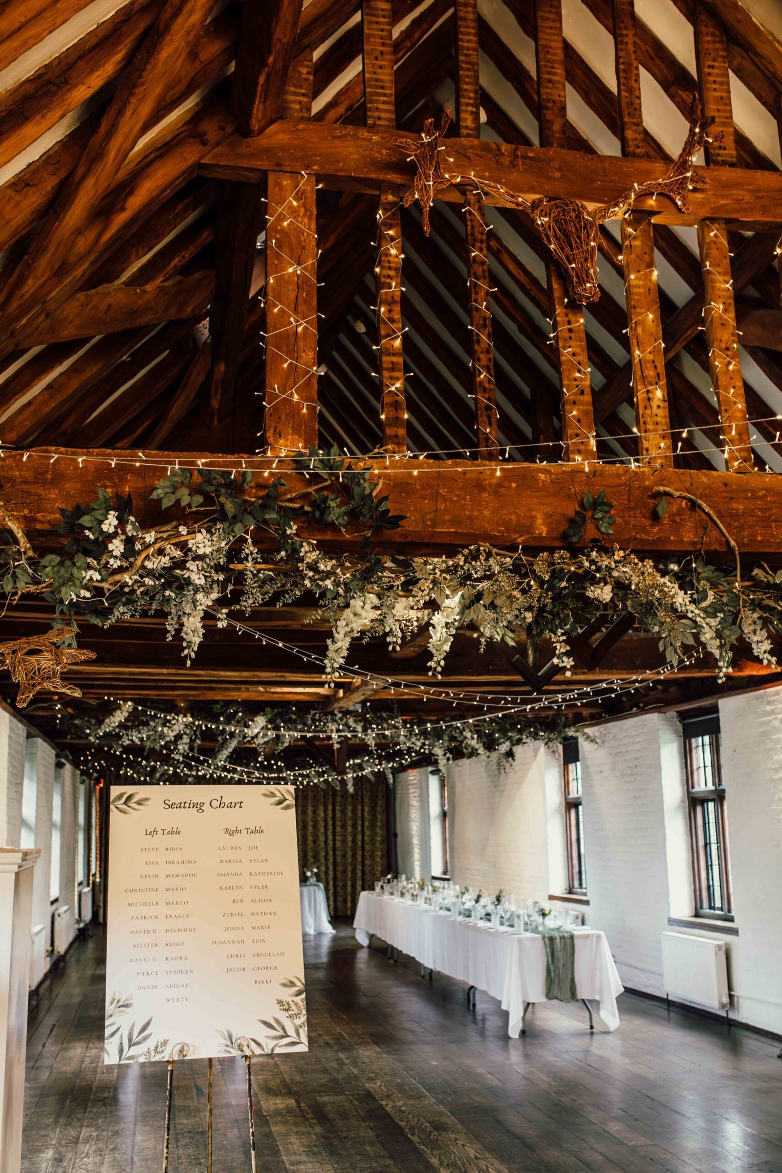 Timber beams and wedding table decorations inside Tudor Barn