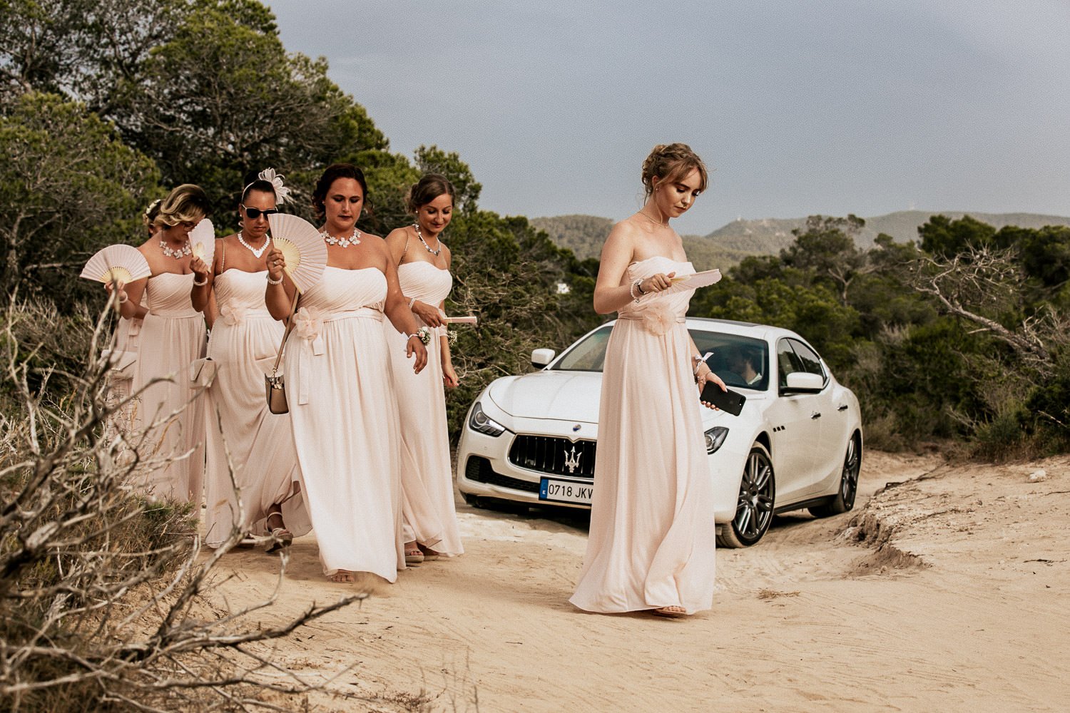 Monica and her bridesmaids beside the wedding car