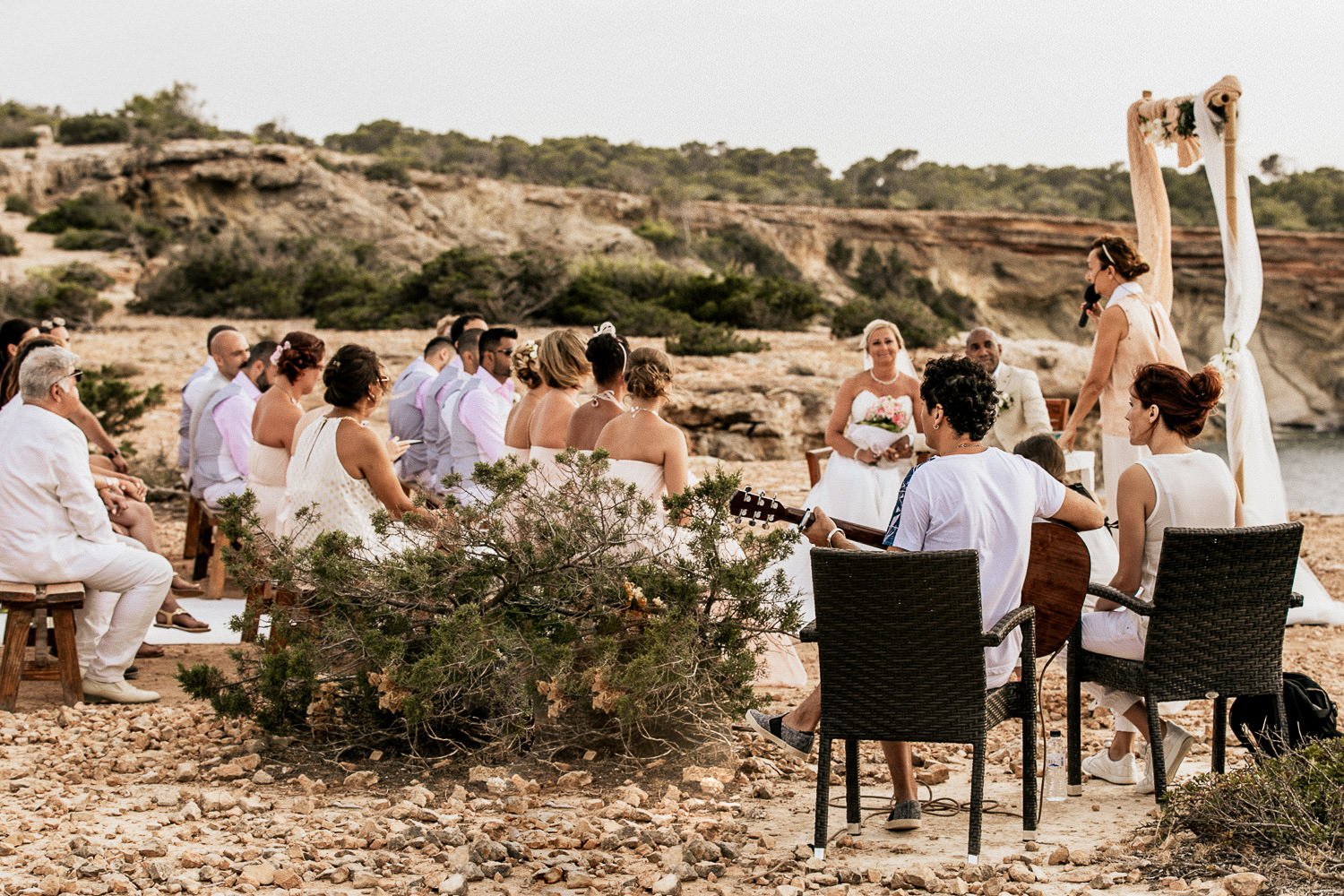 Guests gathered for an outdoor wedding ceremony overlooking the sea