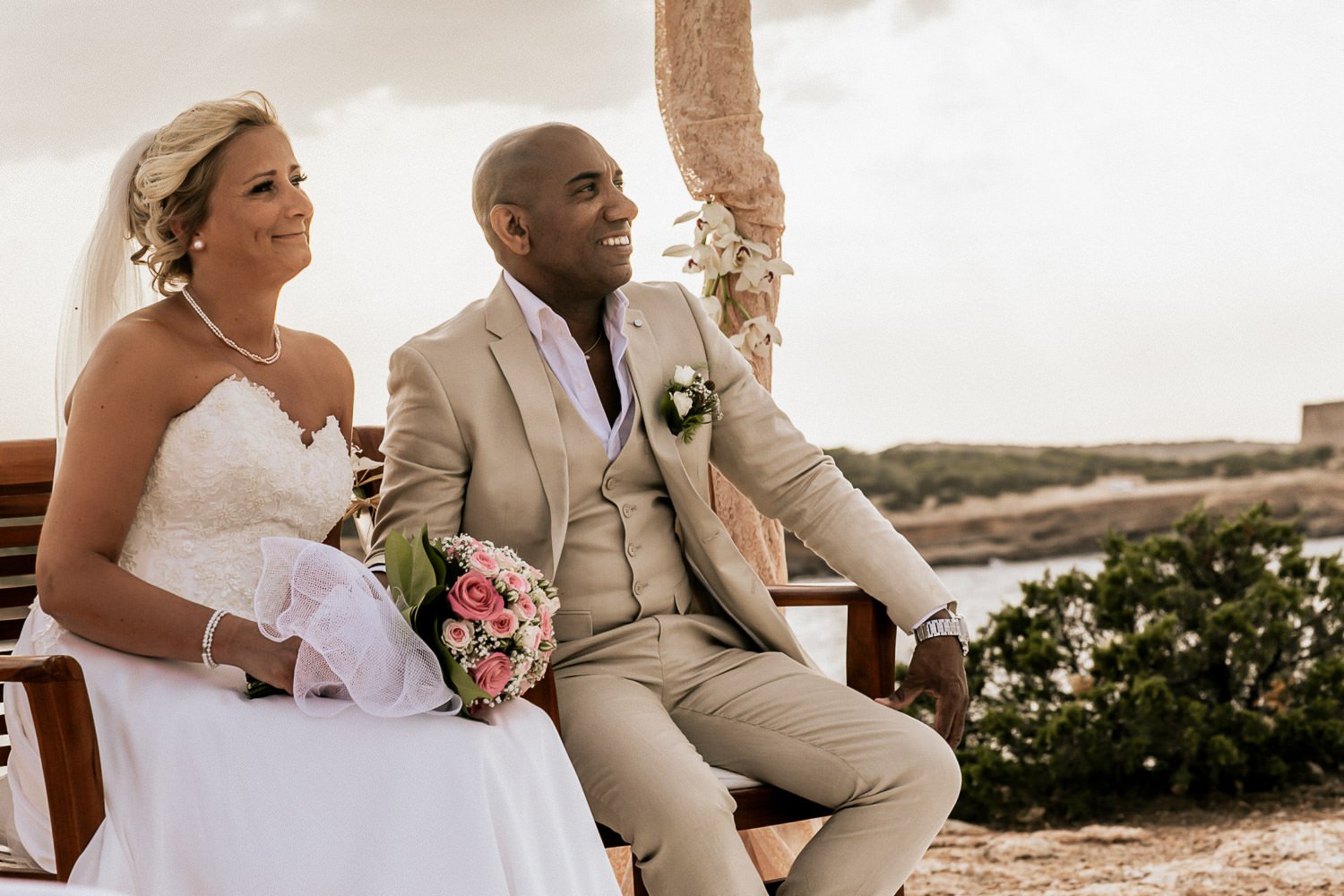 Mike and Monica seated together during their outdoor ceremony