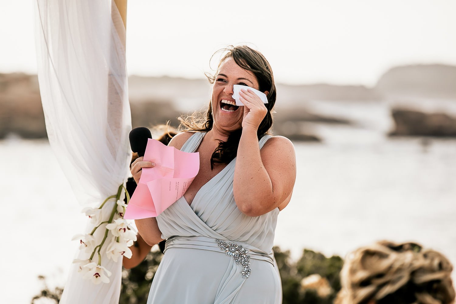 A wedding guest laughing during a speech