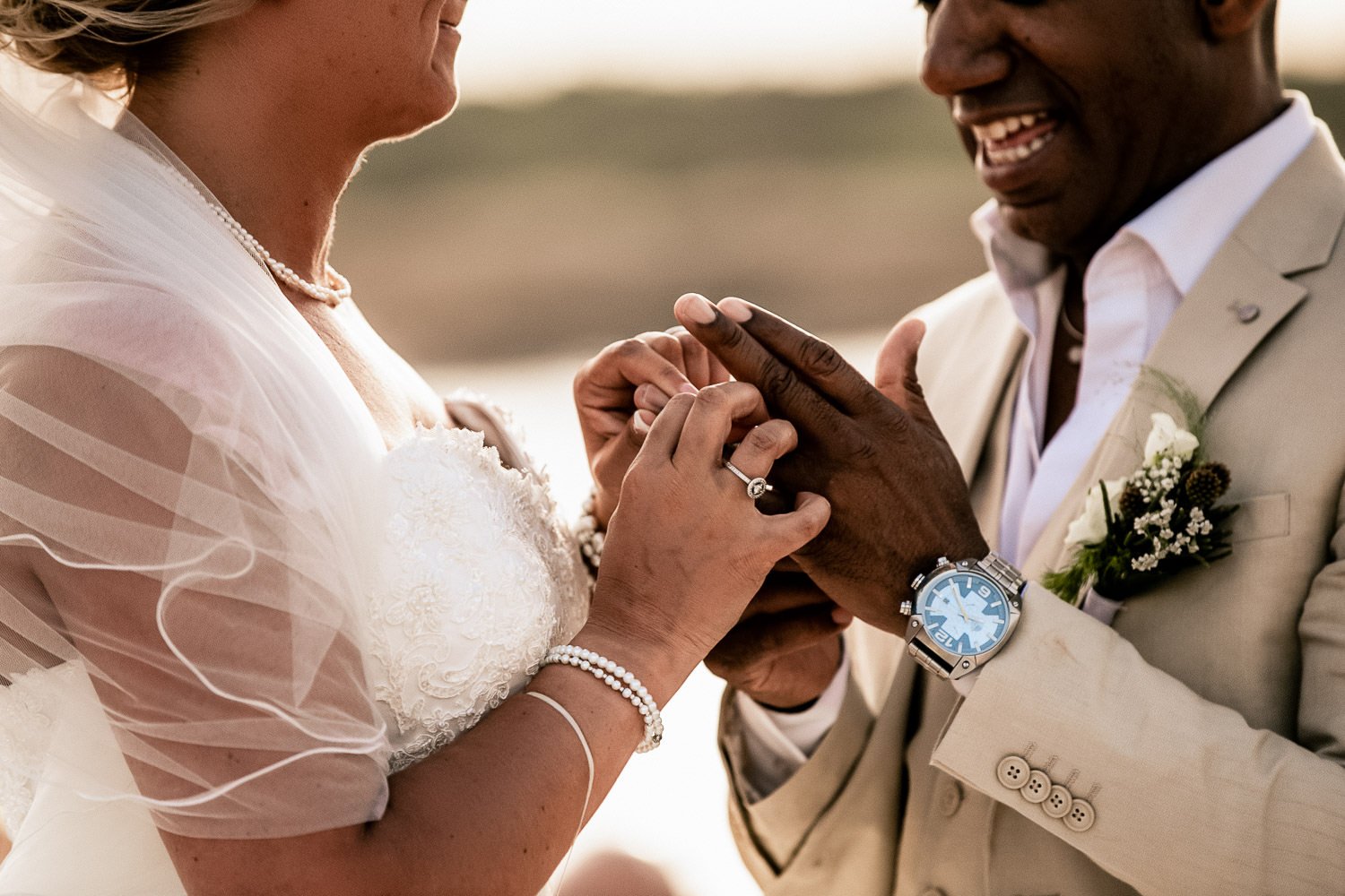 A close view of the couple’s hands during the ring exchange