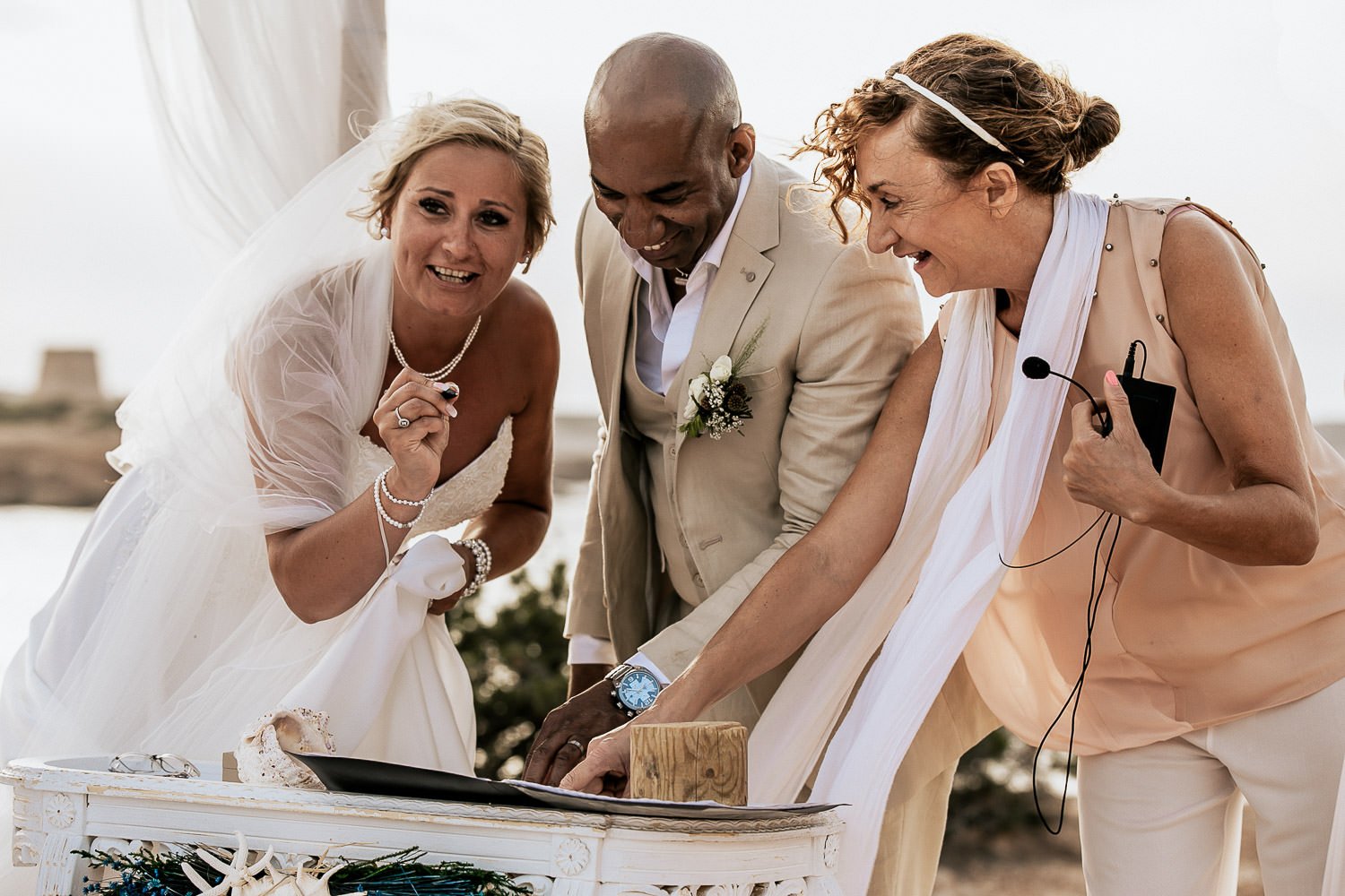 Mike and Monica signing their wedding documents with a friend